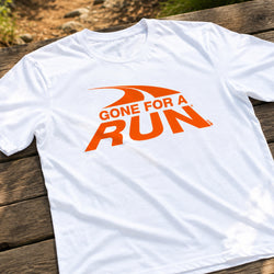 A white short-sleeve t-shirt with an orange graphic reading 'GONE FOR A RUN' laid flat on a rustic wooden surface.