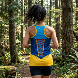 Person running in a forest wearing a colorful tank top with a superhero design.