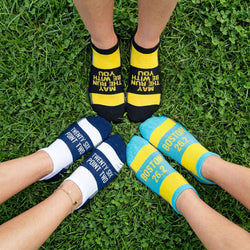 Three pairs of socks in a circle with motivational text on grass