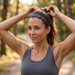 Woman adjusting her headband in a forest setting