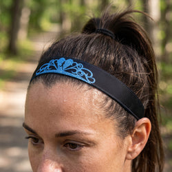 Person wearing a black headband with a blue decorative princess tiara design, blurred background