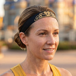 Woman wearing a gold headband with a decorative element outdoors