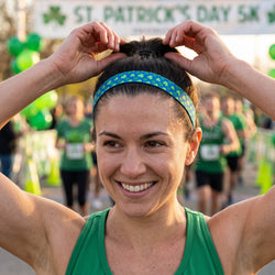 Woman adjusting shamrock headband at a St. Patrick's Day 5K event
