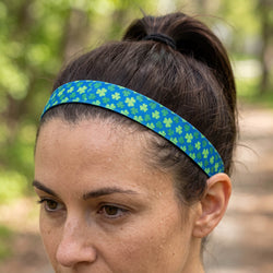 Person wearing a blue headband with green shamrock pattern outdoors