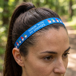 Person wearing a blue headband with 'Running with My Gnomies' text and gnome graphics, Christmas decorations in the background.