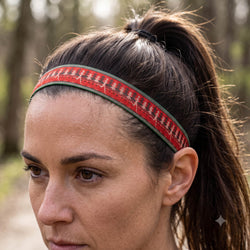 Person wearing a red and green christmas patterned headband with a festive background