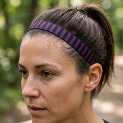 Person wearing a purple and black striped headband outdoors