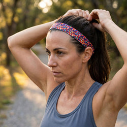 Woman adjusting her hair with a colorful headband outdoors