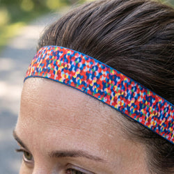 Close-up of a person wearing a colorful headband with a blurred natural background
