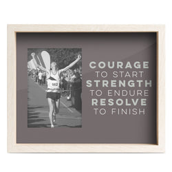 Framed motivational quote with a black and white photo of a runner crossing the finish line.