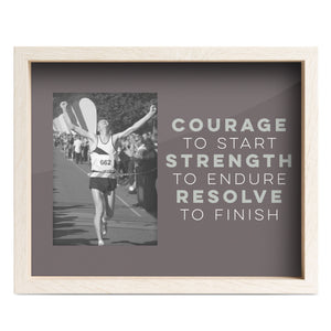 Framed motivational quote with a black and white photo of a runner crossing the finish line.