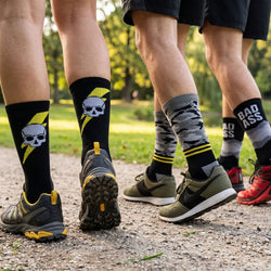 People wearing colorful socks with unique designs outdoors on a path.