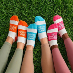 Colorful socks with motivational sayings on grass