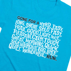 A close-up of a bright turquoise blue t-shirt featuring a typographic graphic of running words in white and black text.