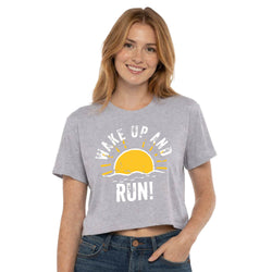 Woman wearing a gray t-shirt with a sun graphic and text on a white background