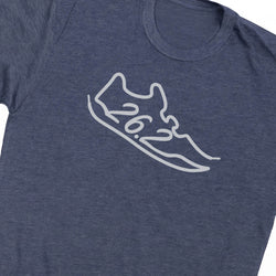 Close-up of a heathered navy blue t-shirt featuring a white outline graphic of a running shoe with the text '26.2' across the center, representing a half-marathon.