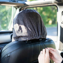 Person folding a hooded towel over a seat inside a vehicle
