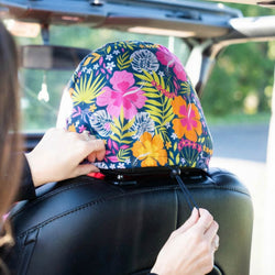 Colorful floral design on a car seat with a person adjusting it.