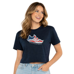 Woman wearing a navy blue t-shirt with a patriotic running graphic design on a white background