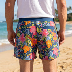 Person wearing colorful floral running shorts on a beach