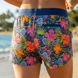 Colorful floral running shorts worn by a person on a beach.