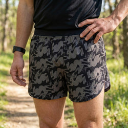 Person wearing black and gray jackalope patterned shorts in a natural setting