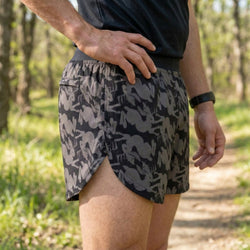 Person wearing jackalope pattered shorts in a forest setting