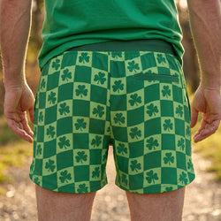 Green checkered shorts with shamrock pattern worn by a person outdoors.