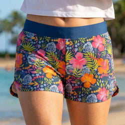 Colorful floral shorts worn by a person at a beach.