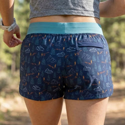 Person wearing blue patterned running shorts with a natural background