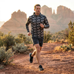 Male running in a canyon wearing a jackalope patterned running hoodie