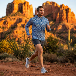 Man wearing a blue running hoodie running in a canyon