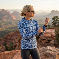 Woman wearing a blue running hoodie behind a mountain range