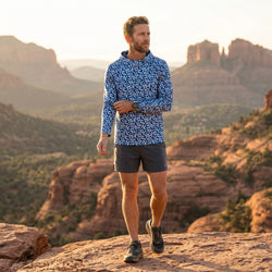 Man wearing a blue running hoodie in mountainous setting