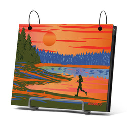 Artistic depiction of a person running by a lake with a sunset, displayed on a bibfolio on a stand.