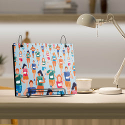 Bibfolio with colorful design of runners on a desk with a lamp and cup in the background