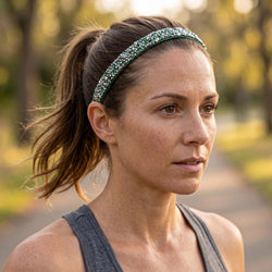 Woman wearing a green headband outdoors with a blurred natural background