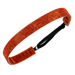 Orange glittery headband with a black strap on a white background