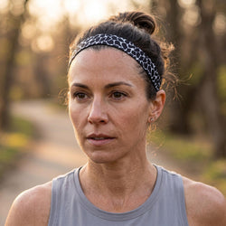 Woman wearing a headband outdoors with a blurred natural background