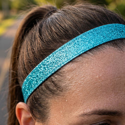 Close-up of a person wearing a blue glittery headband outdoors.