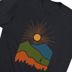 A close-up of a black t-shirt featuring a colorful graphic print of a sun over green, blue, and orange mountains with a small runner silhouette.