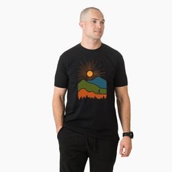 Man wearing a black t-shirt with a colorful mountain design on a white background