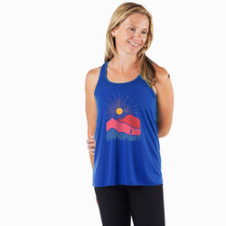Woman wearing a blue tank top with a mountain design on a white background