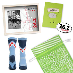 Collection of marathon-themed items including socks, frame, greeting card and sticker with '26.2 Chicago' branding. Includes a green gift bag.