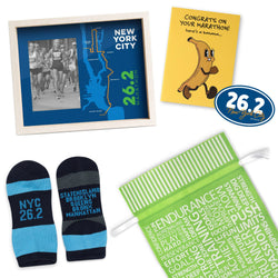 Collection of marathon-themed items including socks, a 26.2 New York City frame, a greeting card, and sticker with a gift bag with running-themed text.