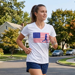Woman running on a suburban street wearing a white t-shirt with an American flag and running woman graphic.