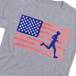 A close-up of a heather gray t-shirt featuring a graphic print of a blue running silhouette overlaid on a stylized American flag with red and white stripes and white stars.