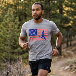 Man running outdoors wearing a gray t-shirt with an American flag and runner graphic.