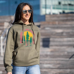 Woman wearing a green hoodie with a happy hour nature graphic, standing outdoors.