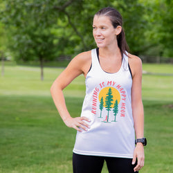 Woman wearing a tank top with 'Running is my Happy Hour' text and tree graphics in a park.